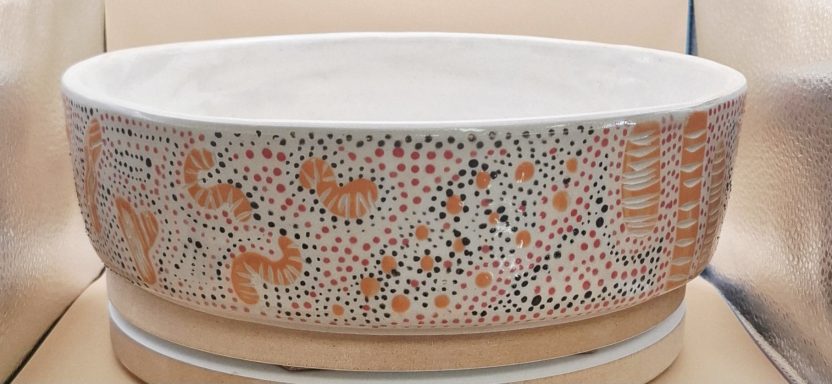 Gâteau en Australie plat à gateau en céramique décoré de motifs colorés et abstraits.