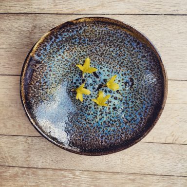 Léopard bleu Bol en céramique avec des fleurs jaunes décoratives sur un fond bleu.